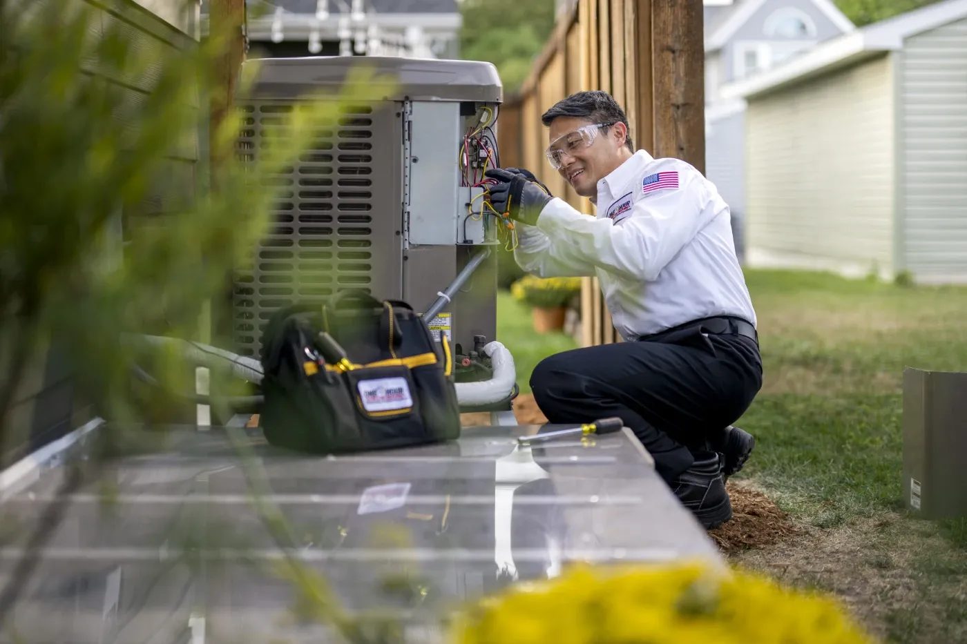 HVAC technician servicing an outdoor home air-conditioning unit